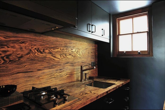 black-kitchen-design-with-wood-rich-grained-backsplash-also-black-kitchen-cabinetry