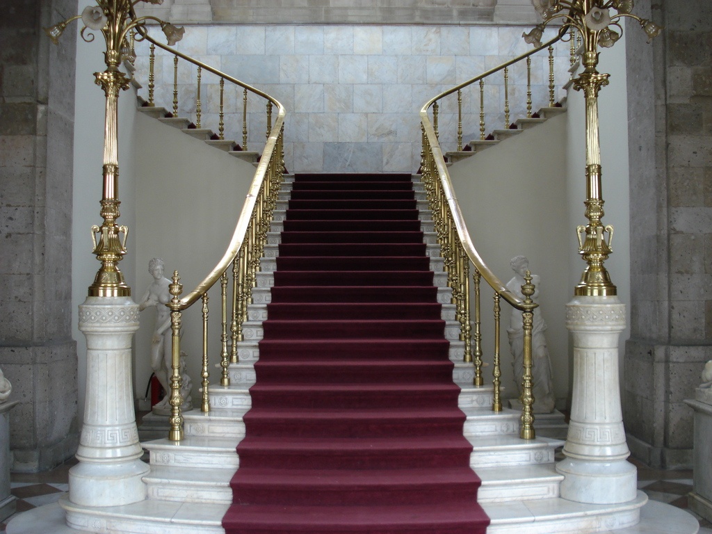 half-landing-stair-with-red-fabric-and-golden-banister