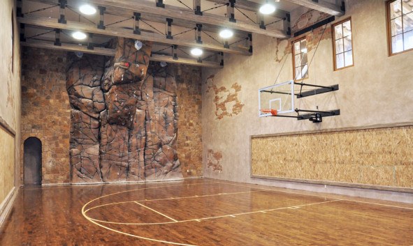 indoor-basketball-court-with-laminate-floor-feat-amazing-stone-climbing-wall-and-track-lighting-idea-591x353