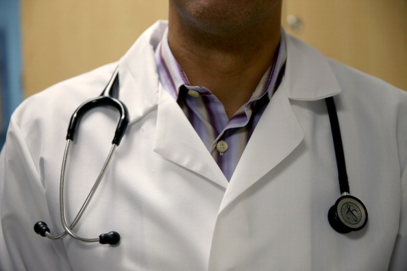  A doctor wears a stethoscope as he see a patient 