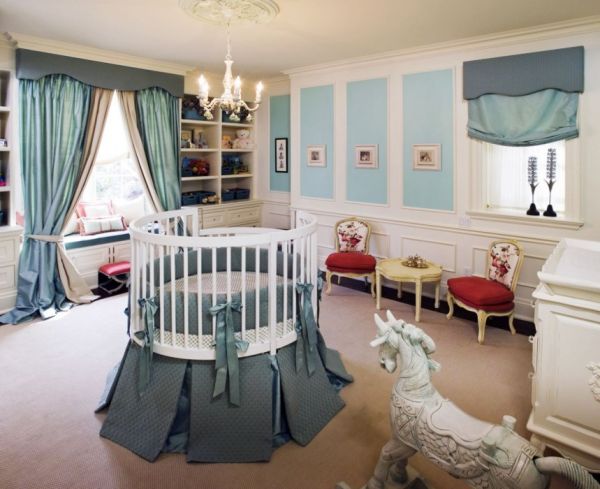 colorful-nursery-with-round-baby-cribs-and-chandelier-also-white-and-blue-wall-color-and-classic-chair-plus-wooden-classic-table-also-beautiful-curtain