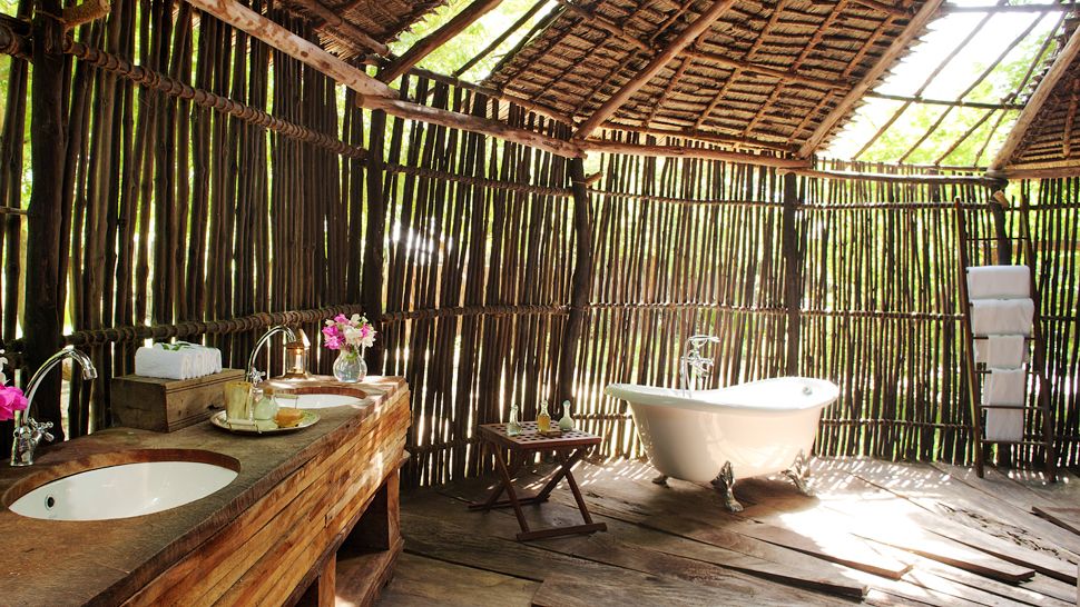 wooden-outdoor-bathroom-wall-combined-with-white-tub-also-wooden-vanity-on-rustic-wooden-floor