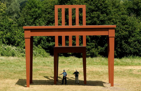 LONDON ? JUNE 22:  People examine the giant sculpture of a table and chair by artist Giancarlo Neri in Hampstead Heath on June 22, 2005 in London, England. The 30ft (9m) sculpture titled 'The Writer' is a tribute to the loneliness of writing, and will be on Parliament Hill for four months before returning to Rome. (Photo by Scott Barbour/Getty Images)