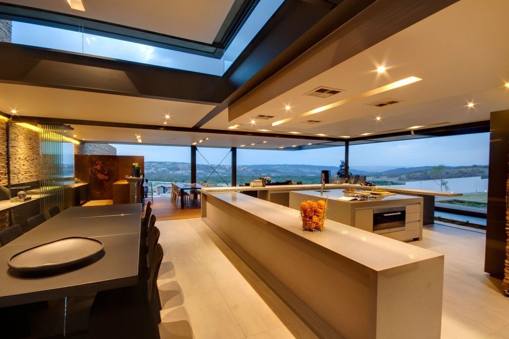 luxury-Spacious-kitchen-with-white-laminate-kitchen-island-marble-countertops-and-black-communal-table-also-frameless-folding-doors-and-glass-skylight-1024x682