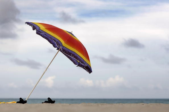  beach umbrella and sandals are seen on the nearly empty beach