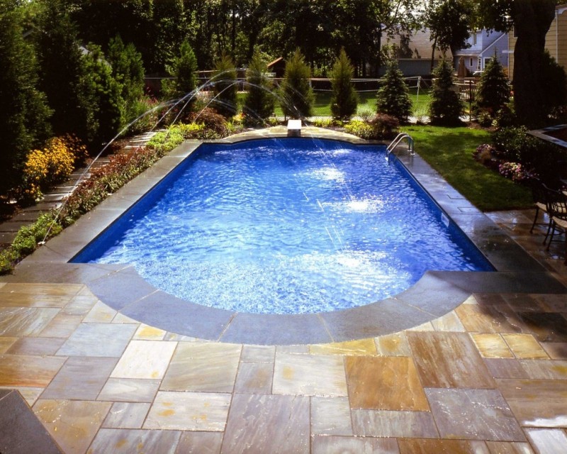 backyard swimming pool with water spraying 