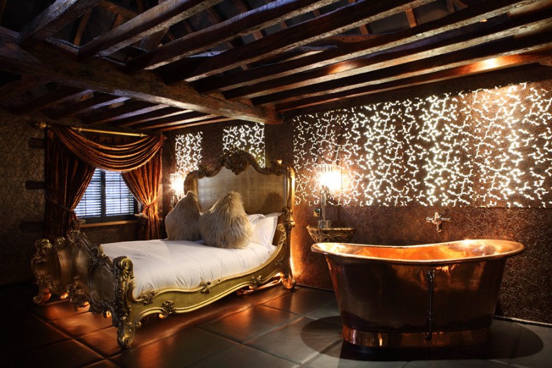 bedroom with gold bed and tub