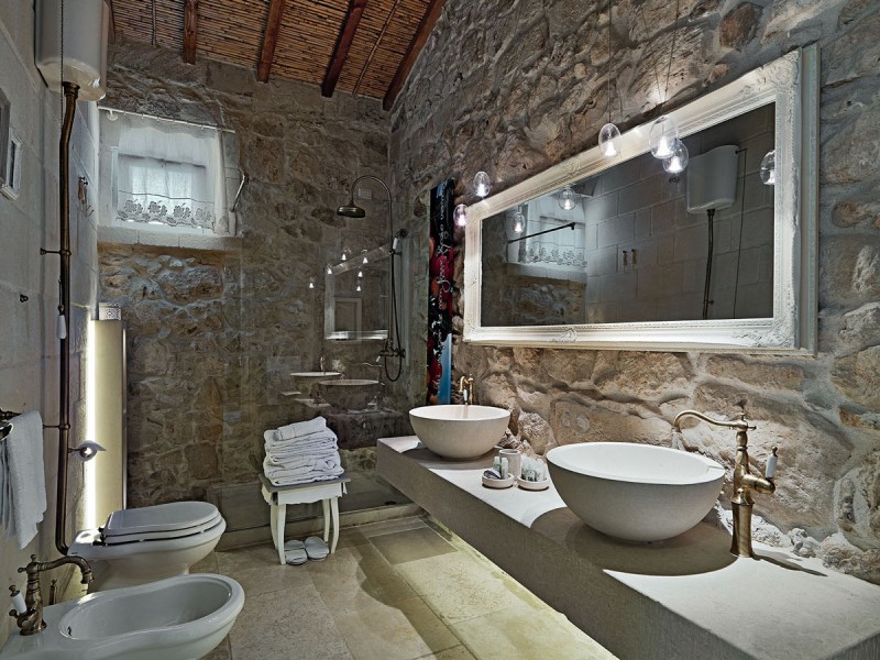 bathroom with stone walls and double sinksa