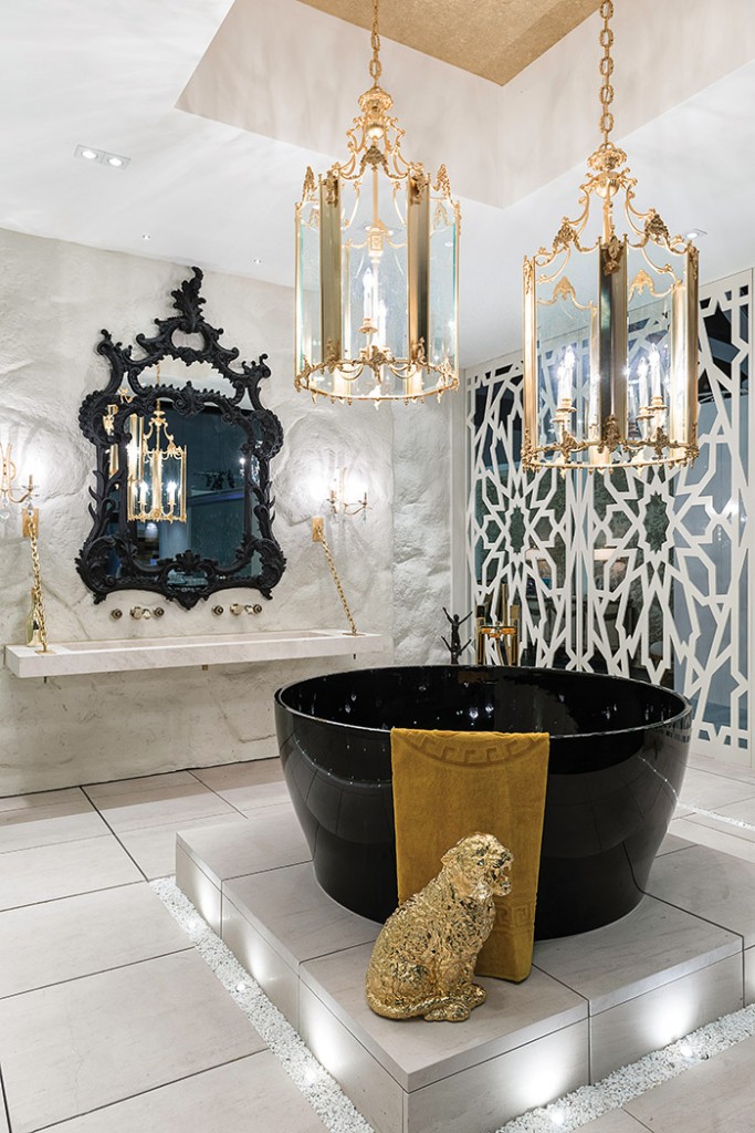 luxurious bathroom with round black tub and two gold chandeliers