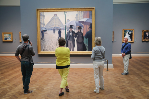 Visitors look over Paris Street; Rainy Day by the French artist Gustave Caillebotte at the Art Institute of Chicago on September 17, 2014 in Chicago, Illinois. The museum, which draws around1.5 million visitors a year, has been named the best museum in the world by TripAdvisor. The museum has nearly 1 million square feet of exhibit space and 300,000 pieces of art in its permanent collection. 