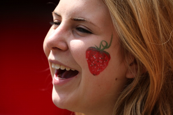 Woman with strawberry on her face