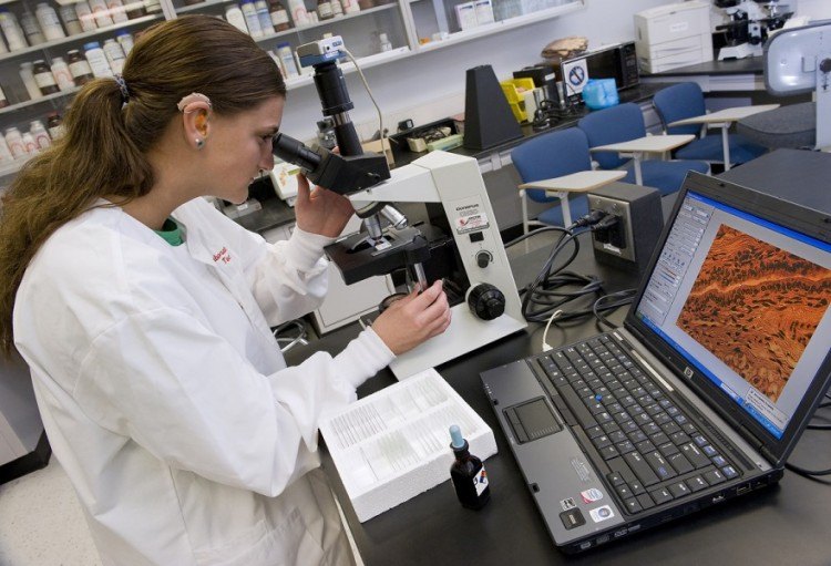 scientist looking into microscope