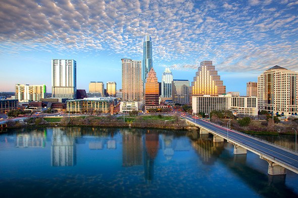 The Austin Skyline in Austin, Texas, shines on a late afternoon. The iconic Austin highrises are reflected in Lady Bird Lake.