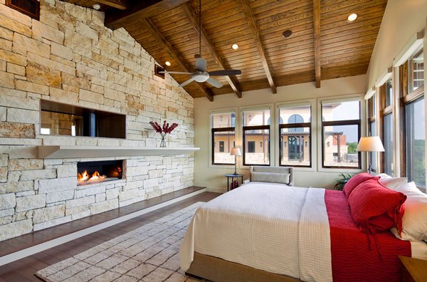 cool custom home with rustic fireplace in bedroom