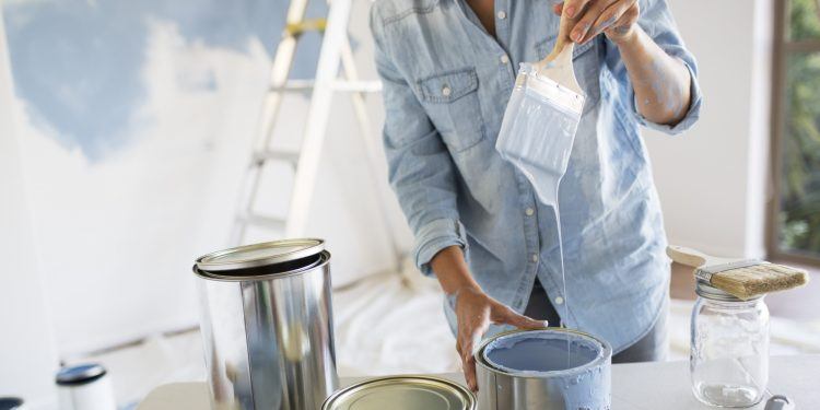 Woman holding paintbrush with blue paint