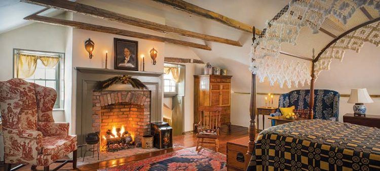 old fashioned bedroom with fireplace and four poster bed