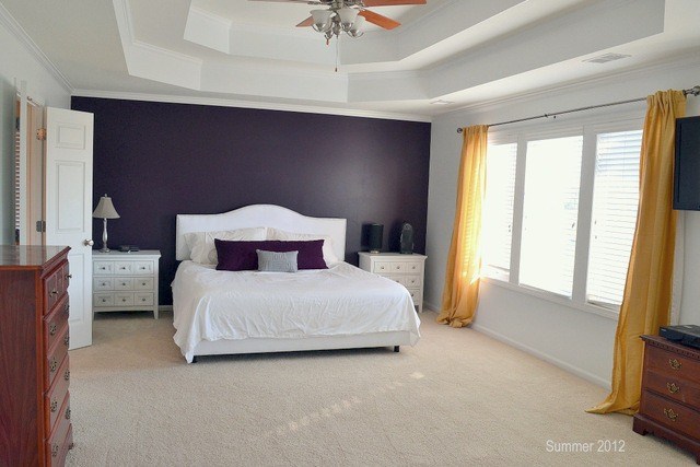 simple bedroom with purple accent wall