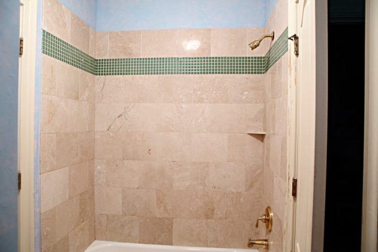 green accent tile inside glass shower