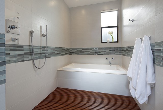 contemporary bathroom with hardwood flooring and shower tile