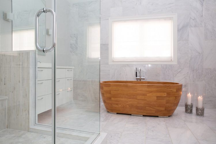 bathroom with glass shower and wooden tub