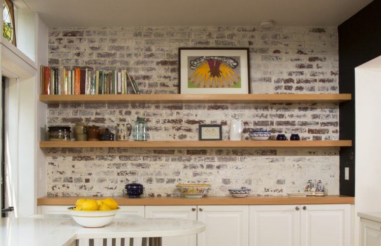 floating wooden shelving with brick wall