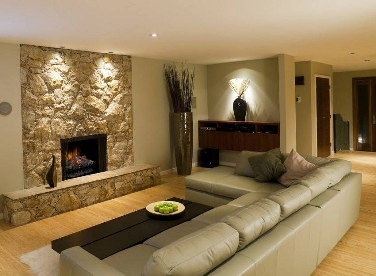 basement living room with stone fireplace