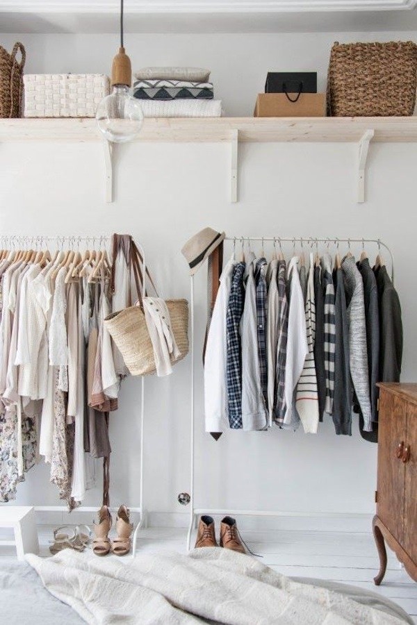 closet with clothing racks and floating shelving