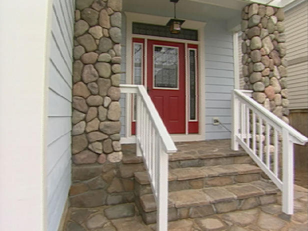 stacked stone front porch with red front door