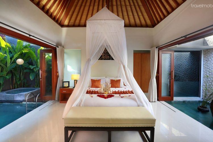 tropical bedroom with wooden ceiling and pool