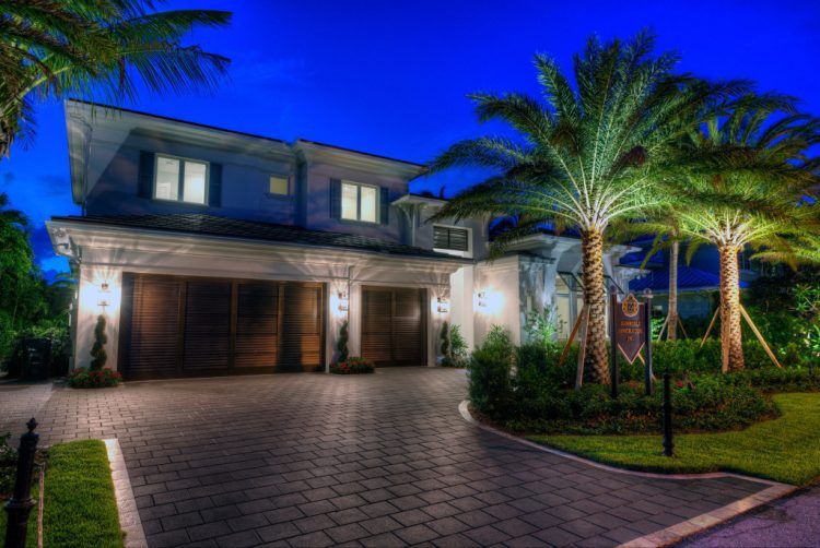 home with palm trees and brick driveway