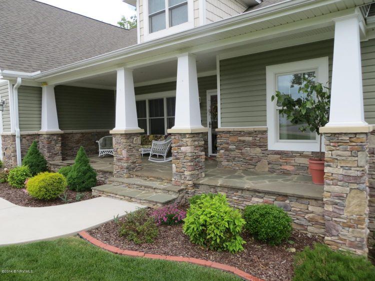 beautiful front porch made of stone with white pillars