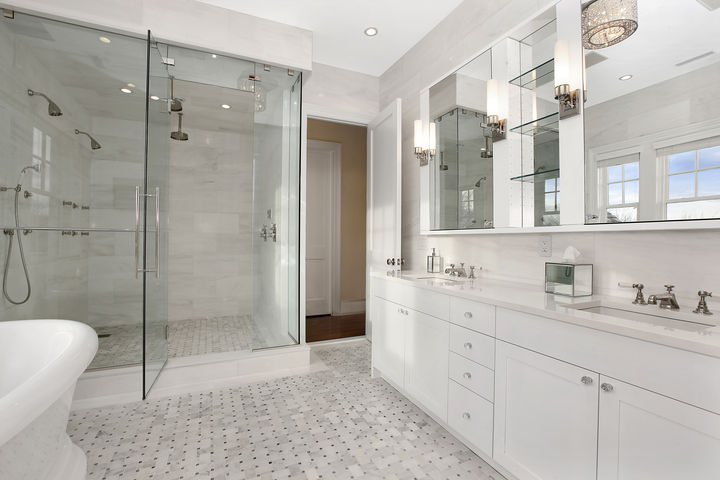 all white bathroom with glass enclosed 