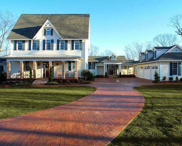 american country house with long brick driveway