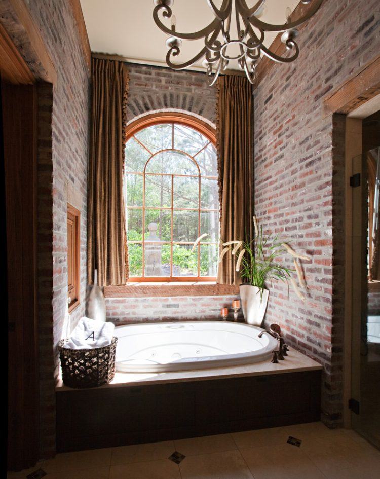 round bathtub surrounded by brick wall