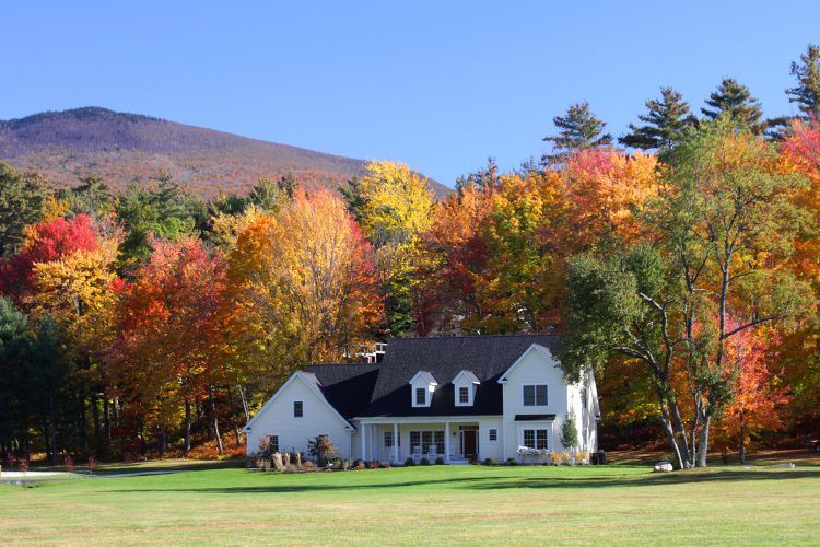 country home surrounded by fall foliage