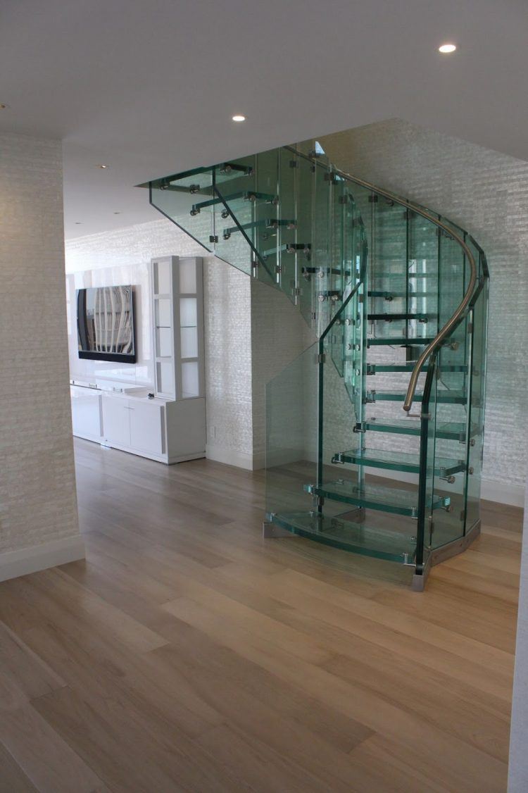 glass spiral staircase with hardwood flooring