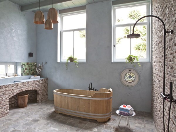 bathroom with wooden freestanding tub with brick wall