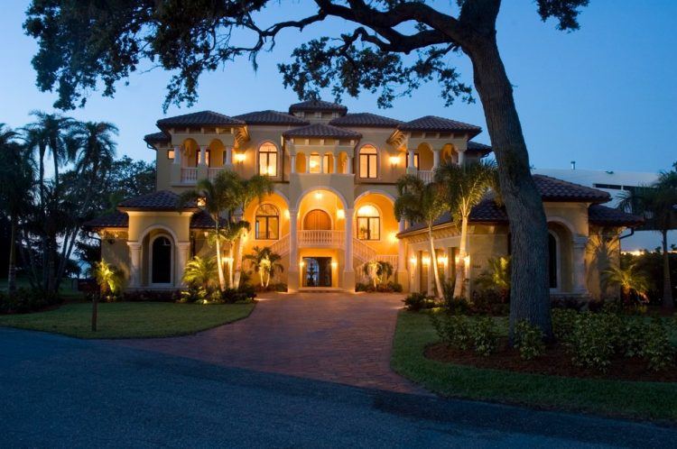 lavish home with balcony and brick driveway