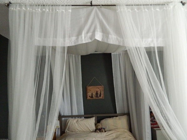 beautiful canopy bed with large white drapes