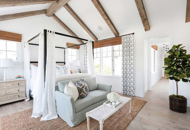 white bedroom with vaulted ceiling and wood floor