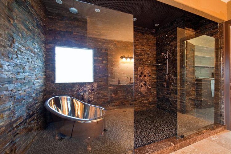 large glass and stone shower with silver tub