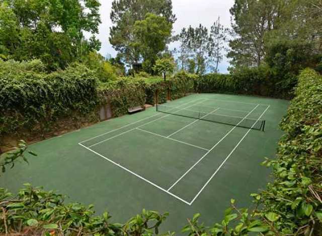 beautiful home tennis court surrounded by woods