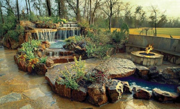 backyard paradise with fire pit and waterfall