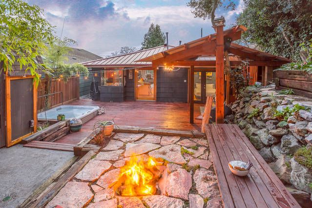 enclosed backyard area with fire pit and hot tub