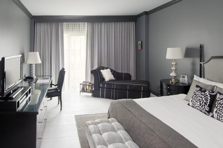 grey-painted-bedroom-with-grey-curtains-combined-by-black-white-lounge-chair-and-black-wooden-cabinet-with-desk-also-black-chair-on-ceramics-flooring