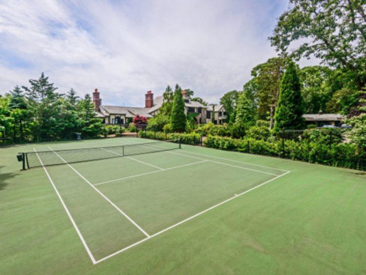 spacious home tennis court with beautiful landscaping