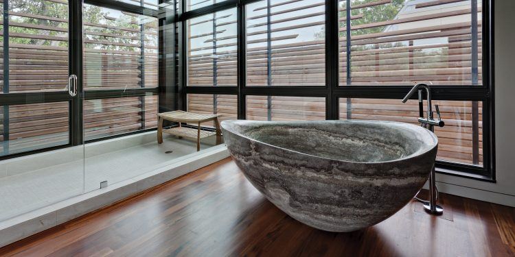 modern bathroom with wood floor and freestanding tub