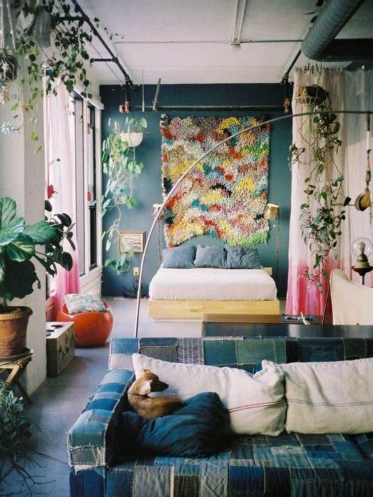 bedroom with hanging plants and colorful tapestry