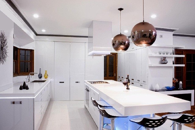 modern white kitchen with gold lighting fixture