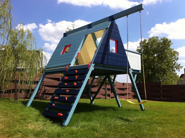 cool triangle shaped playhouse with climbing wall